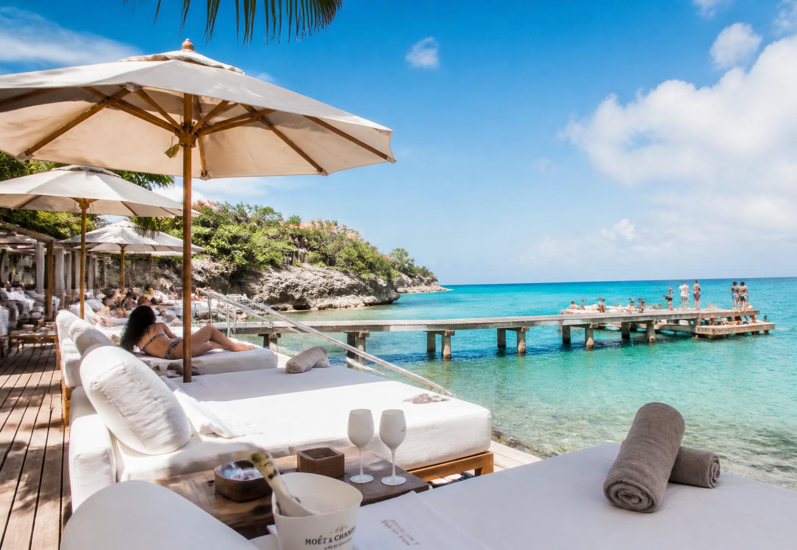 Ligbedden en bar aan een turquoise strand op Curaçao